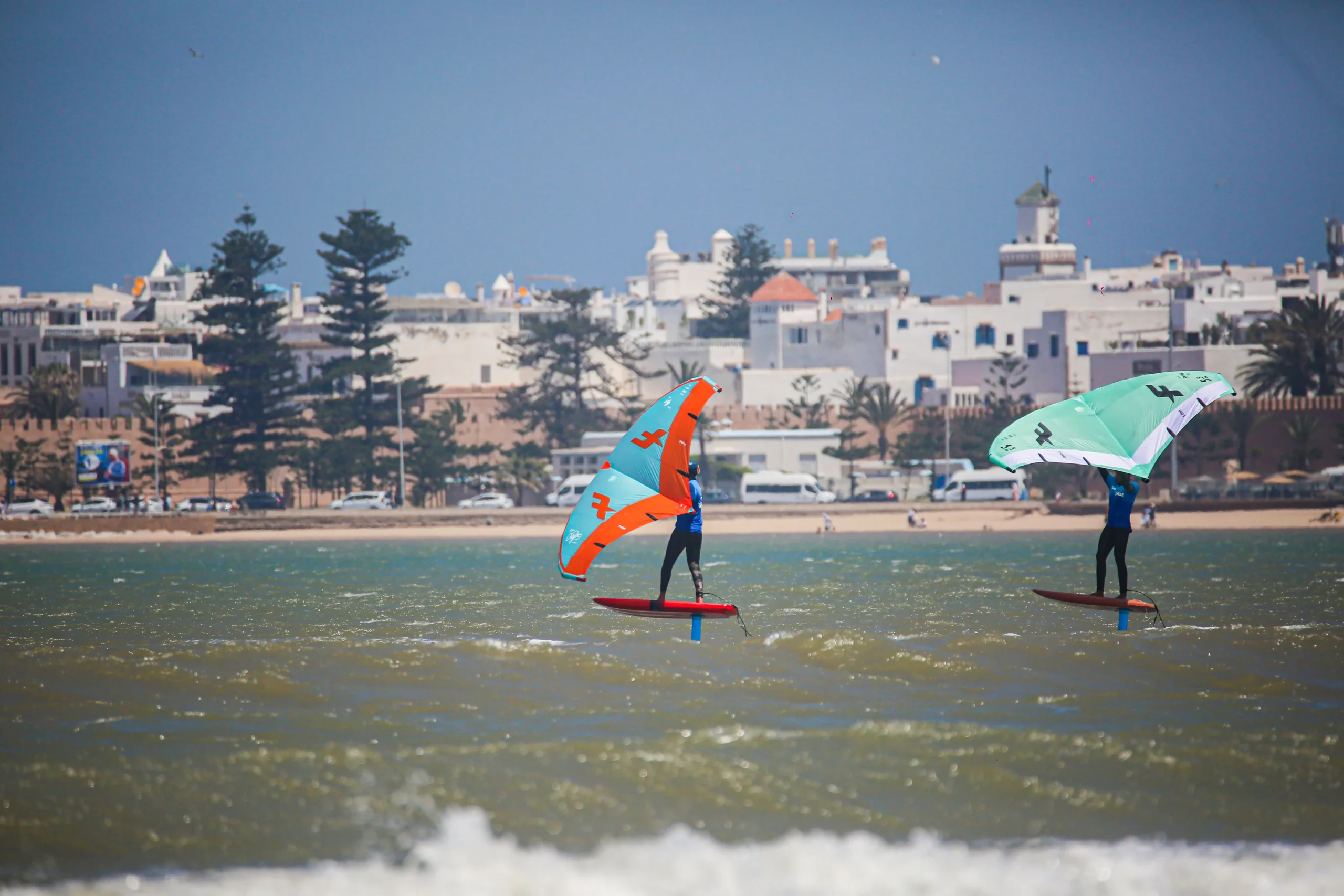 Wingfoilers dans la baie d'Essaouira avec la ville en arrière-plan